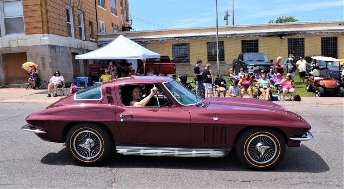 Jacci waves to the crowd from the Corvette during the Wakefield, MI, Fourth of July Parade.