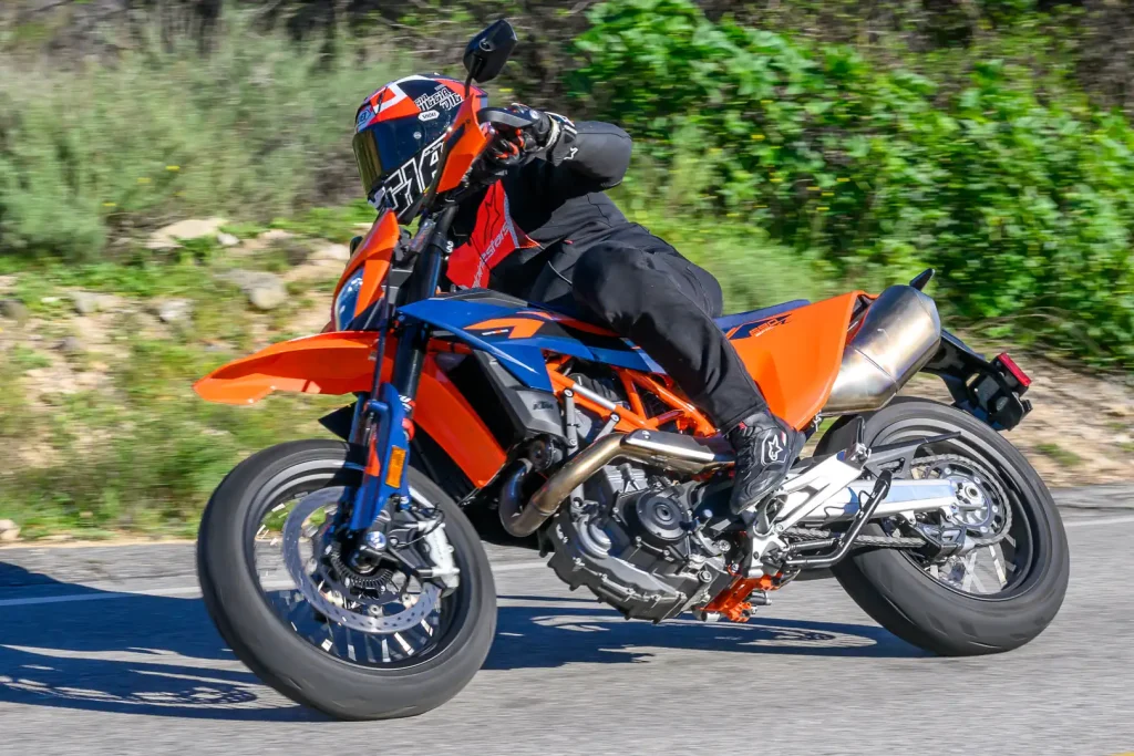 2026 KTM 690 SMC R Review: Rider leaning the supermoto bike to the right