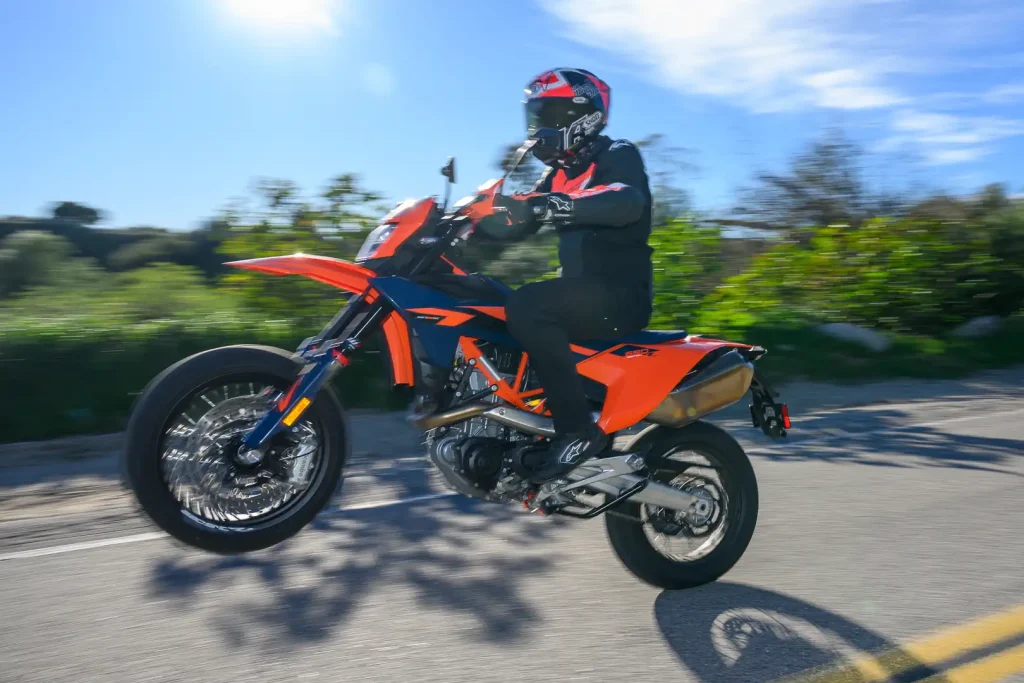 2026 KTM 690 SMC R Review: Rider popping a wheelie