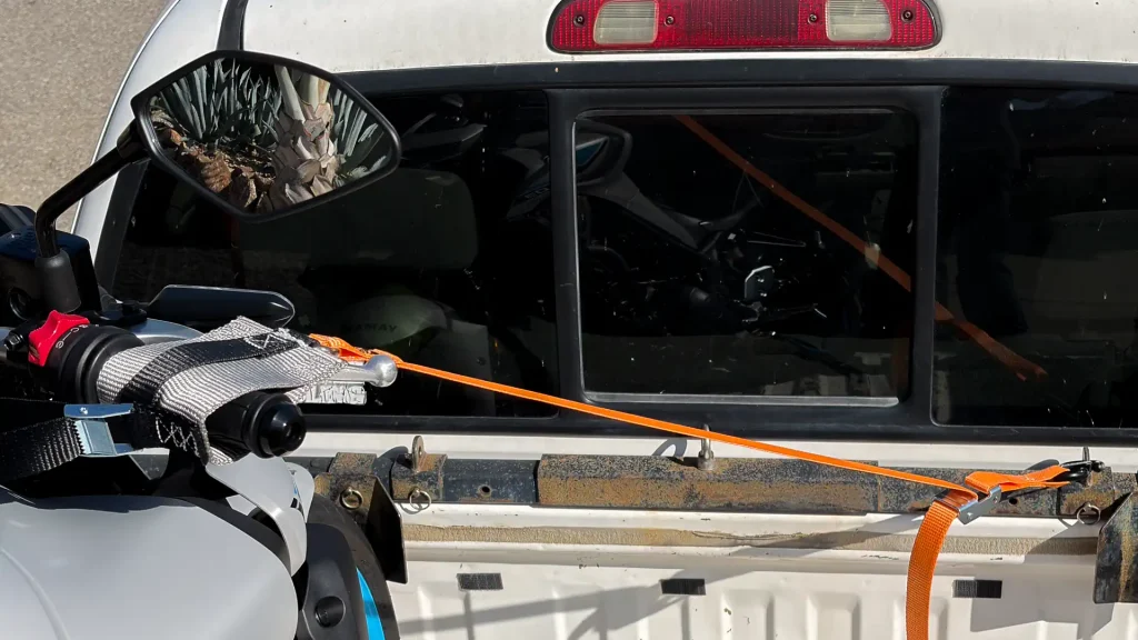 The integration of the tie-down, sheath D-ring, and mounting hook are all shown.