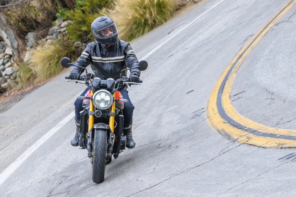 Motorcycle rider leaning into a left turn.