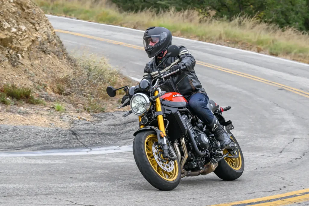 Motorcycle rider in a sweeping right hand turn on a vintage-style motorcycle