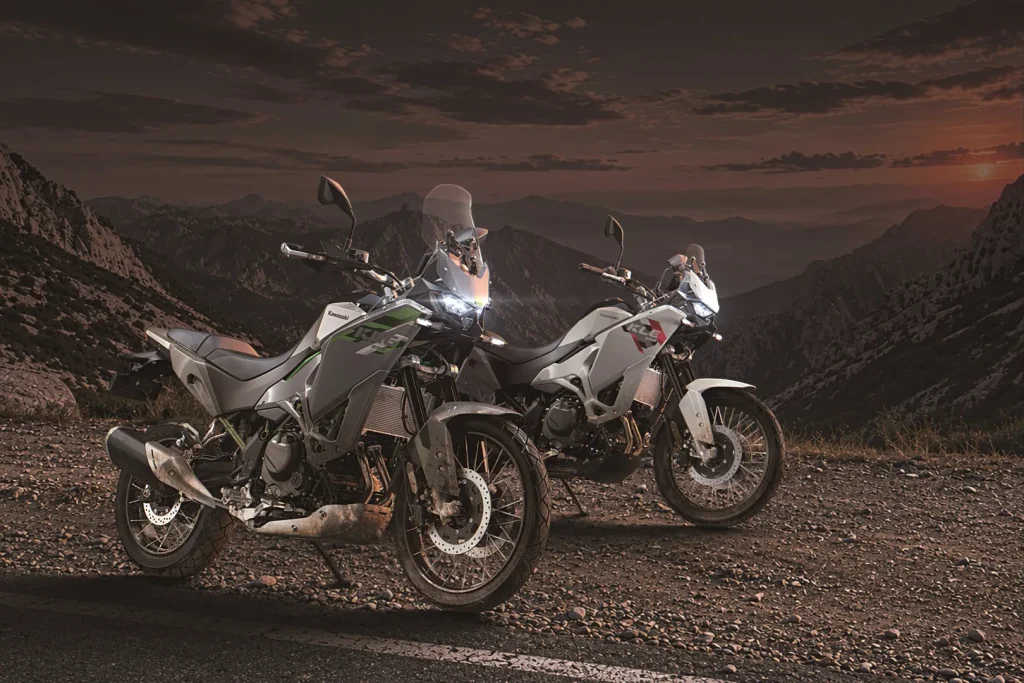 Kawasaki KLE650 SE and standard KLE650 parked on a mountain road at dusk