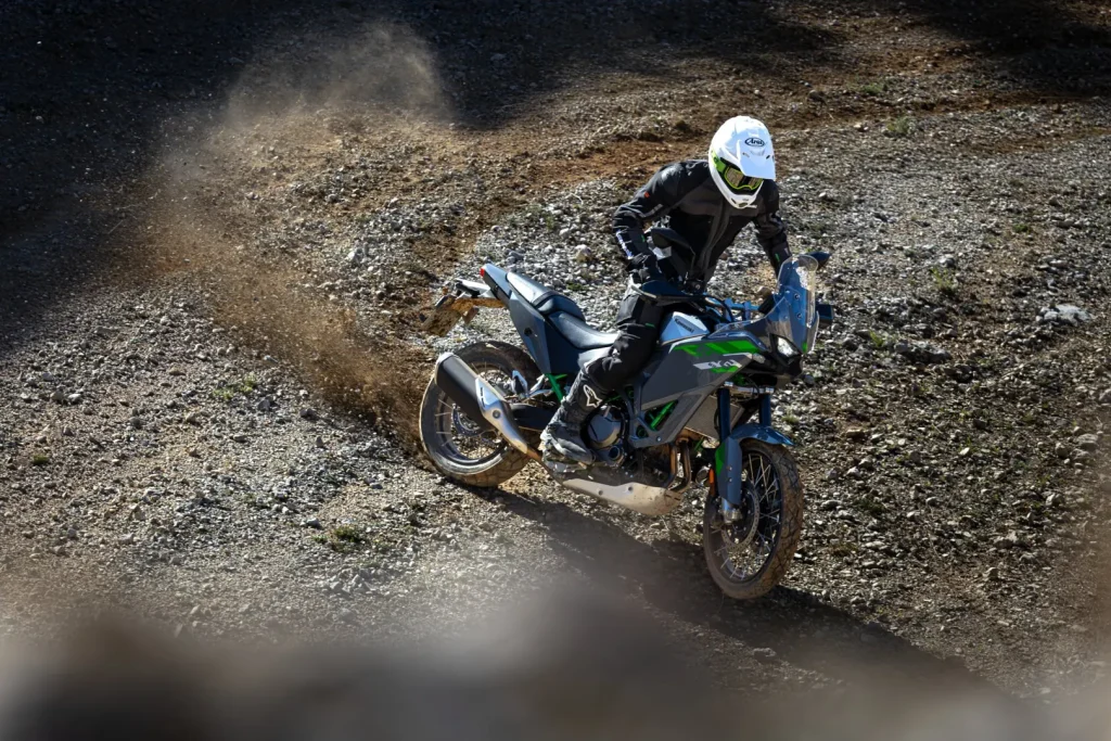 2027 Kawasaki KLE650 SE throwing dirt in a gravel turn