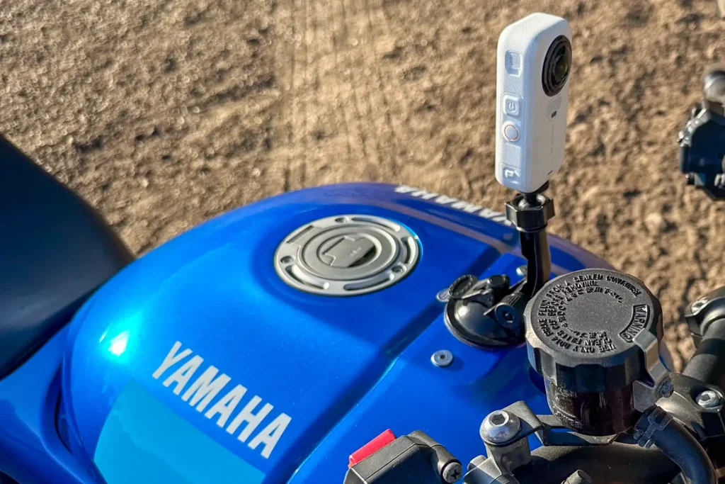Insta360 X6 action camera mounted on the fuel tank of a motorcycle