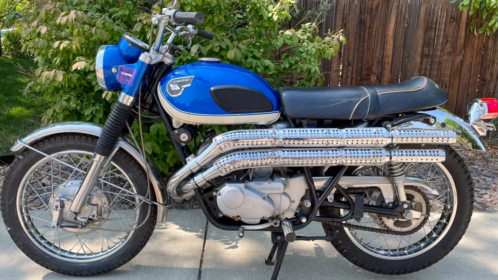 Scrambler Motorcycle History: 1968 Kawasaki Samurai 250 A1SS parked outdoors. Left side view.