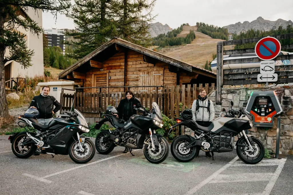 Three Zero electric motorcycles and their riders at a charging station.