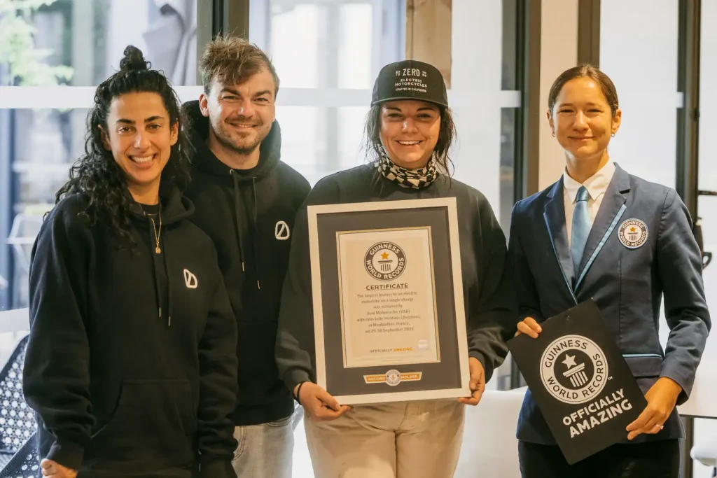 Three electric motorcycle riders and a representative of the Guinness Book of World Records.